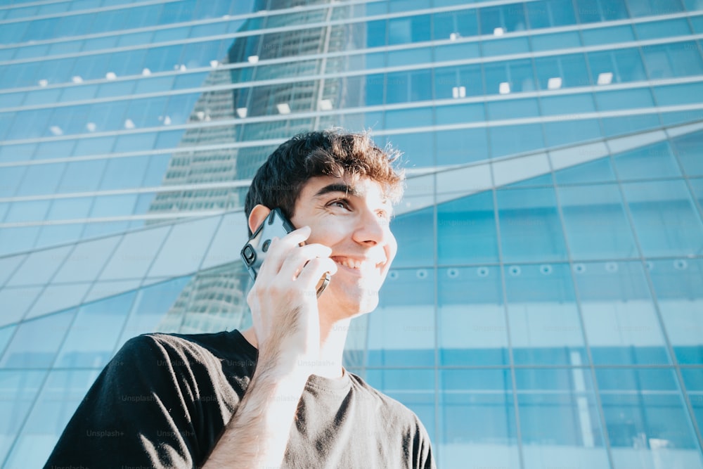 a man talking on a cell phone in front of a tall building