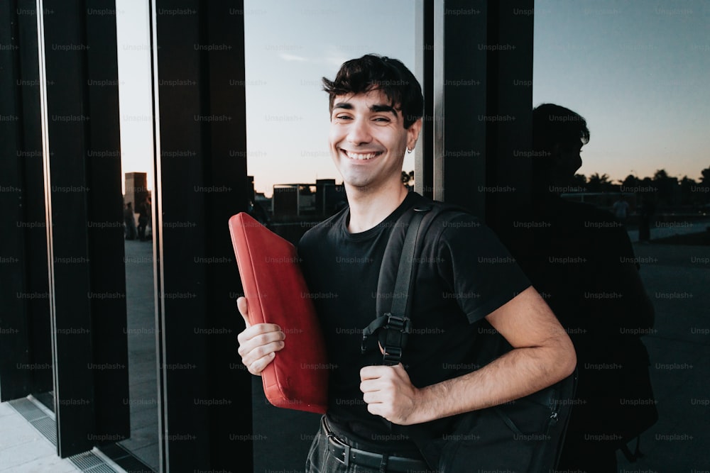 a man holding a red object in front of a window