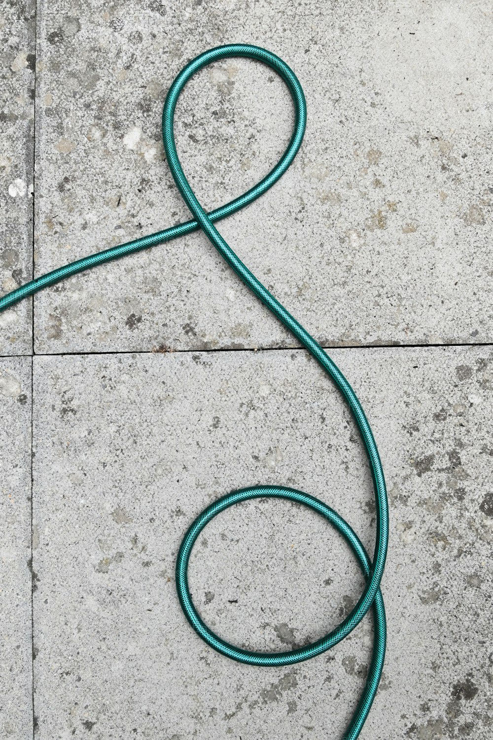 a green hose laying on the ground