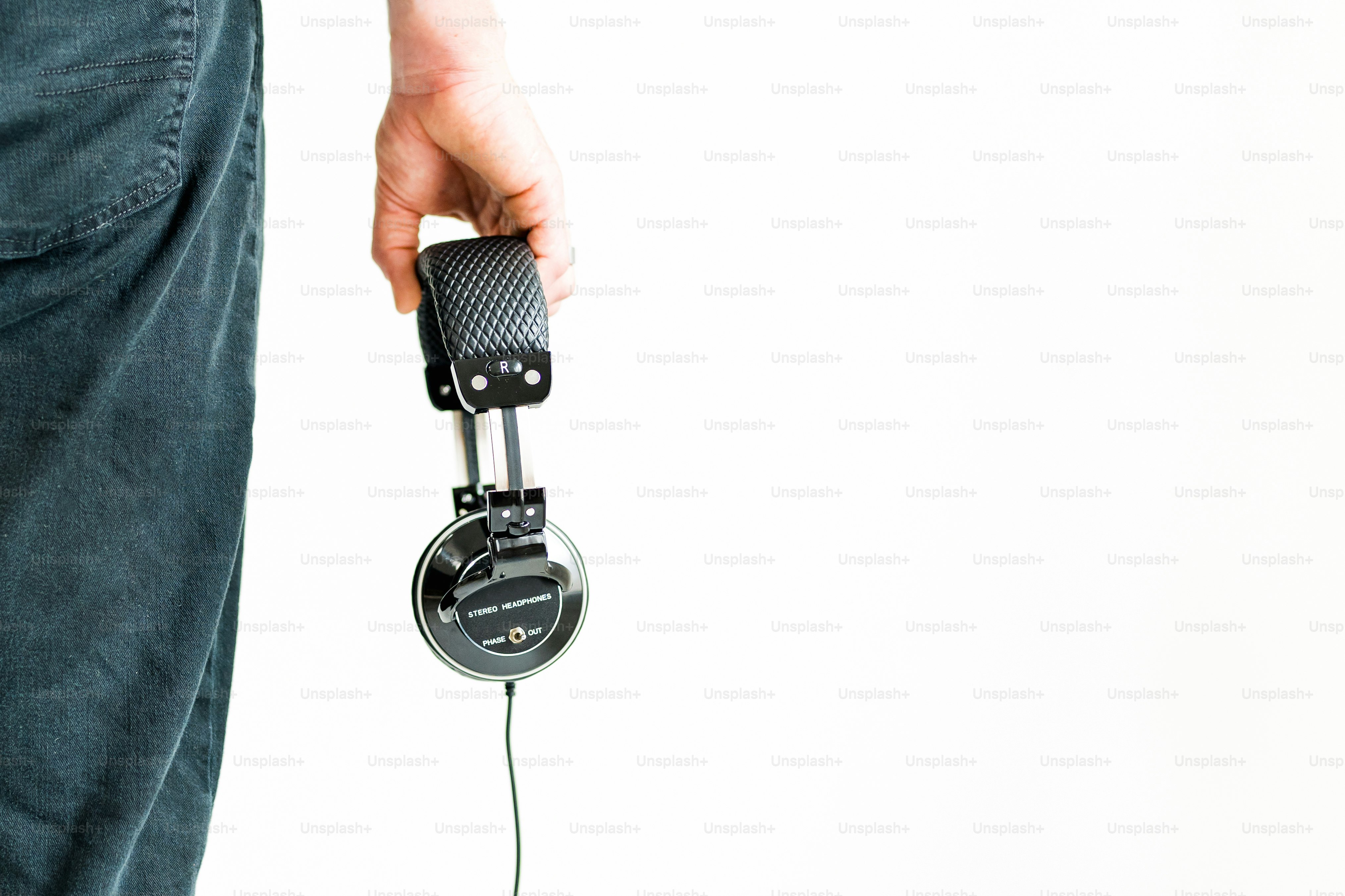 a person holding a pair of headphones in their hand