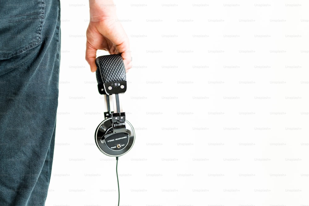 a person holding a pair of headphones in their hand