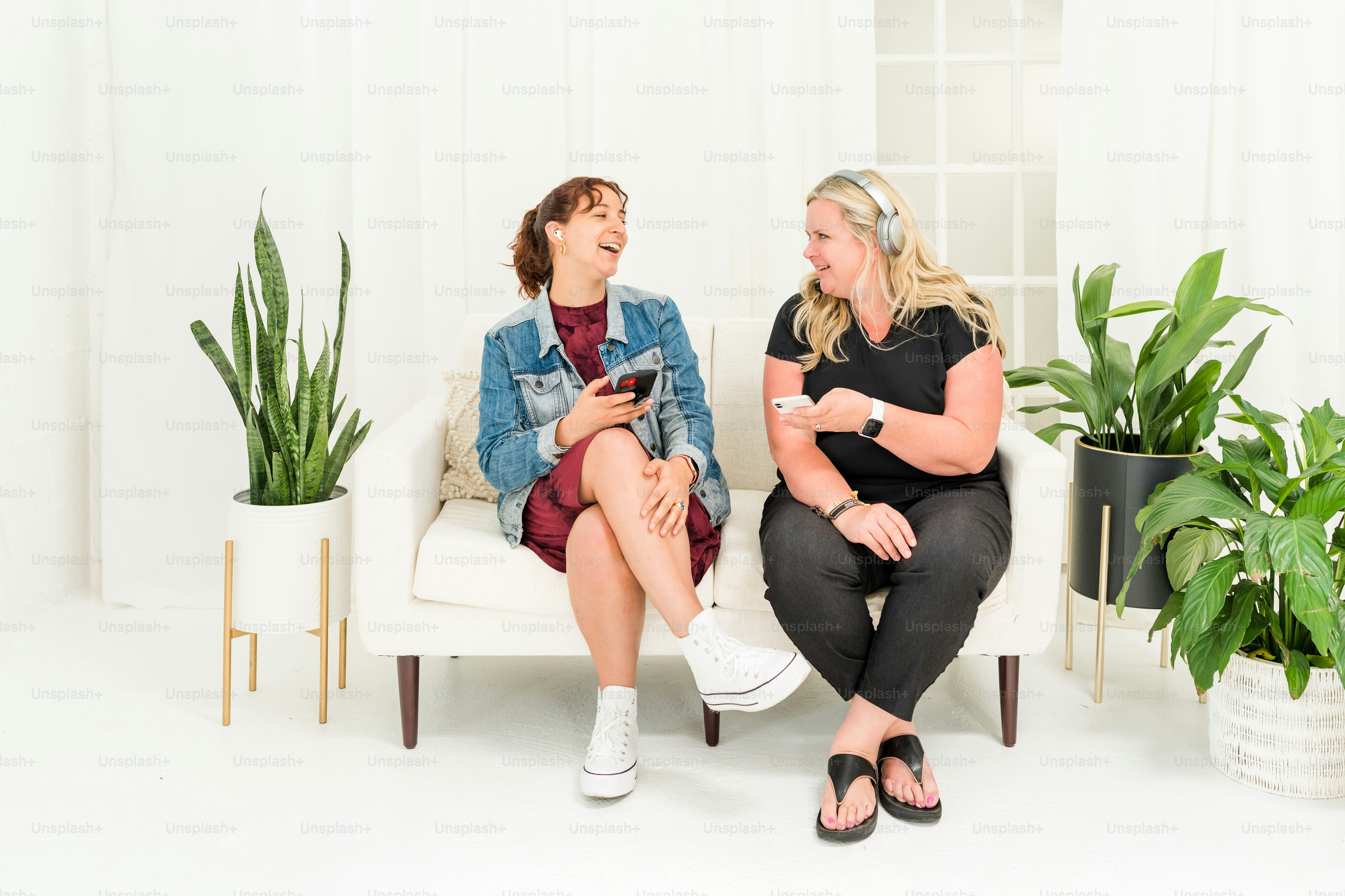 a couple of women sitting on top of a white chair