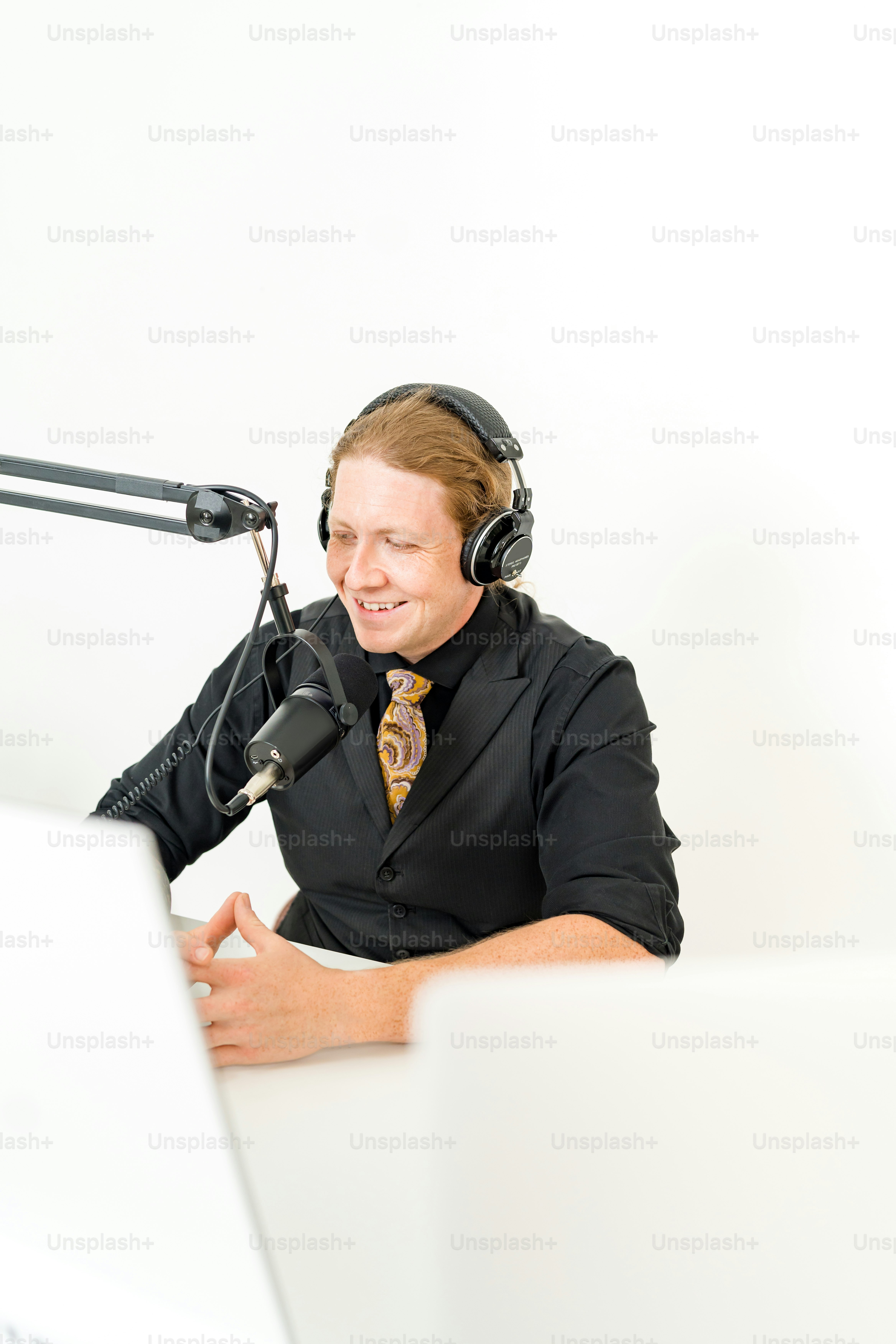 a man wearing headphones sitting in front of a laptop computer
