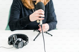 a woman sitting at a table with a microphone and headphones