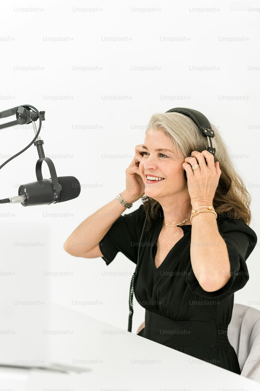 a woman sitting in front of a microphone talking on a cell phone