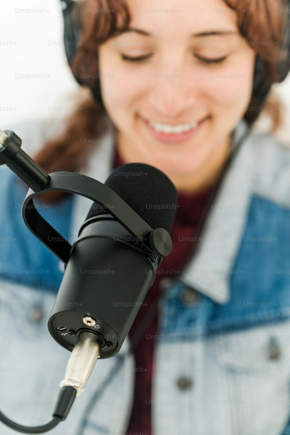 uma mulher com fones de ouvido ligados e um microfone à sua frente