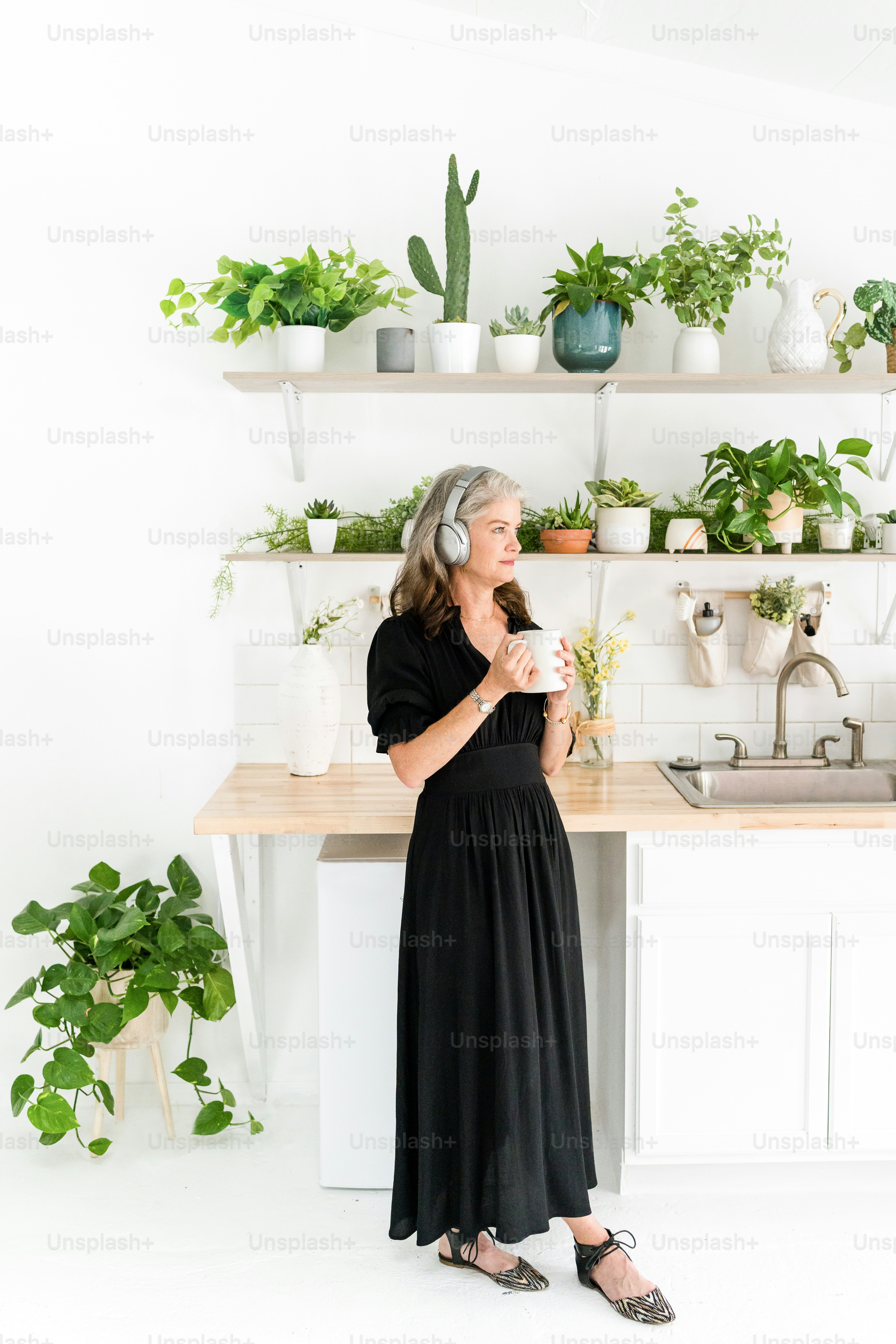 a woman in a black dress standing in a kitchen