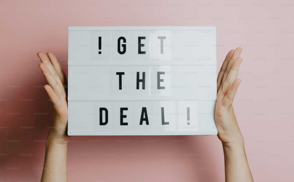 a person holding up a sign that says i get the deal