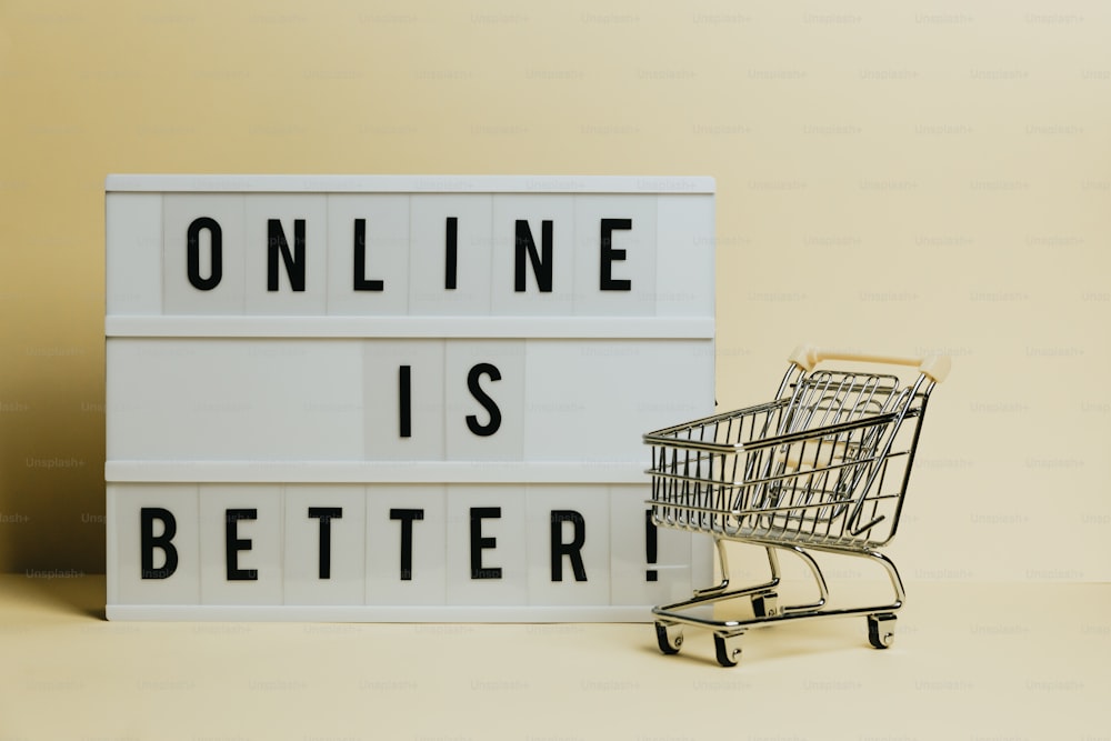 Un carrito de compras junto a un letrero que dice que en línea es mejor