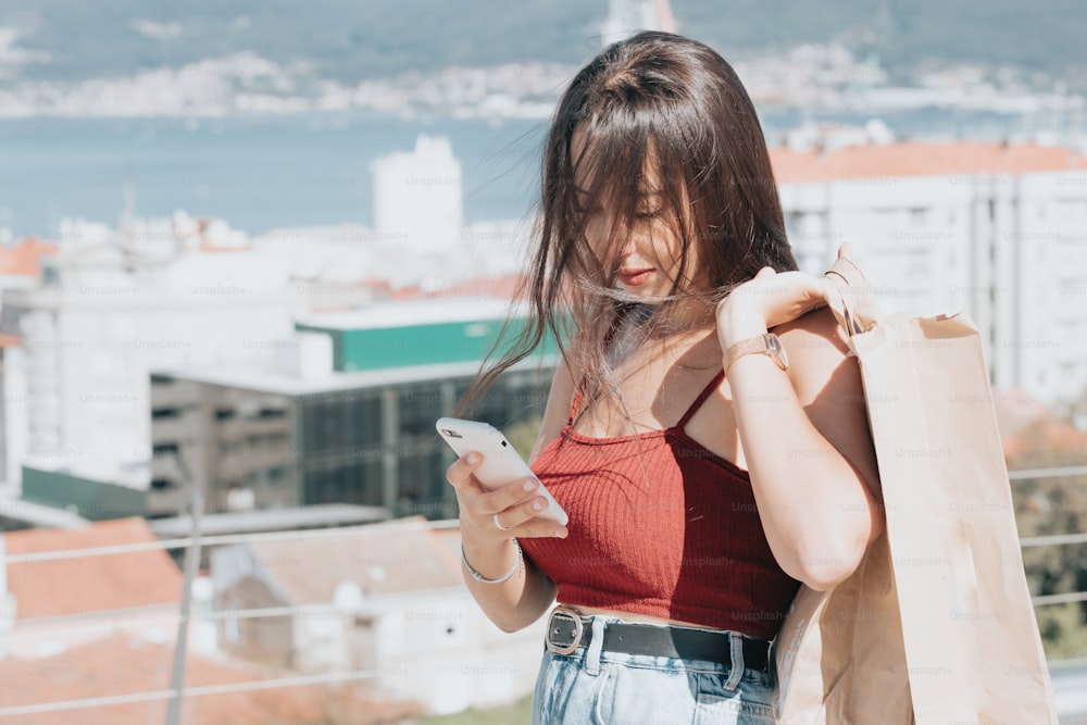 a woman in a red top looking at her cell phone