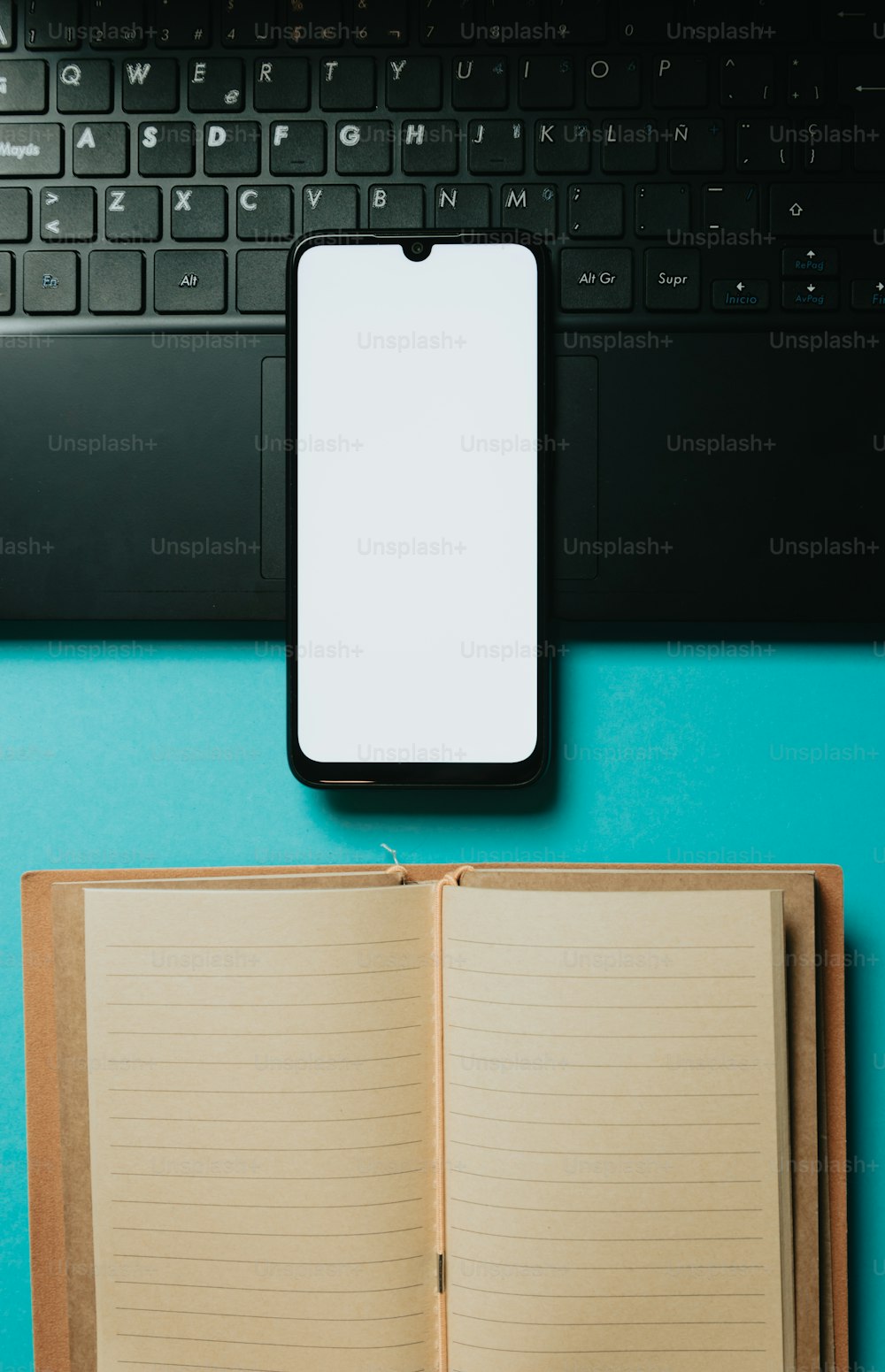 an open notebook sitting next to a laptop computer