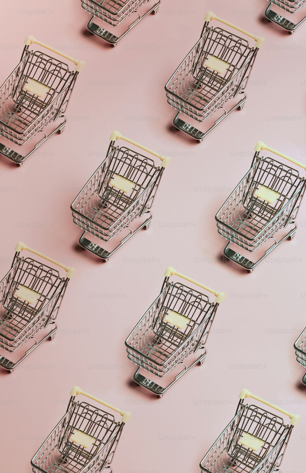 분홍색 표면 위에 앉아 있는 쇼핑 카트 그룹