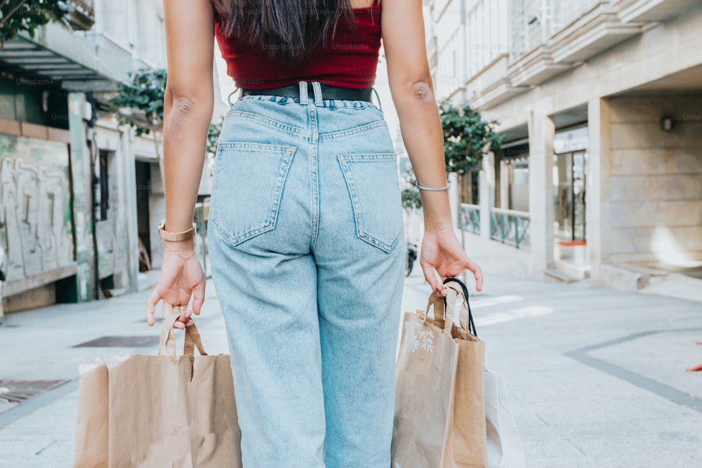 a woman walking down a street holding shopping bags