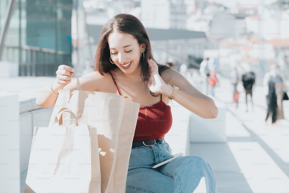 uma mulher sentada em um banco segurando um saco de compras