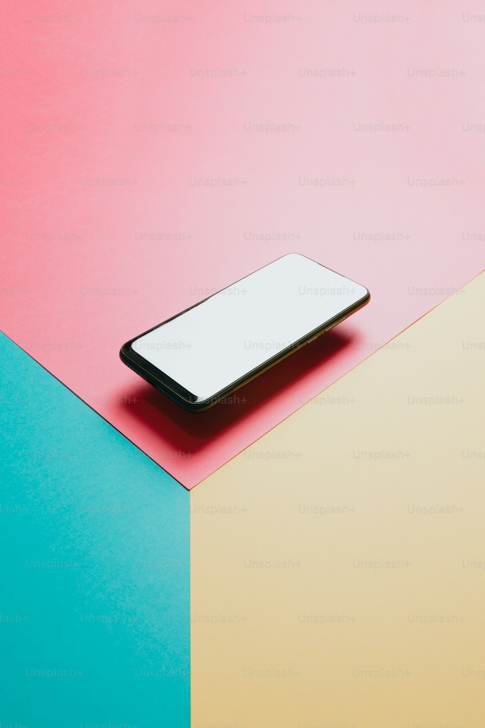 Un teléfono celular sentado encima de una superficie colorida