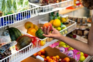 a woman holding a piece of fruit in a store