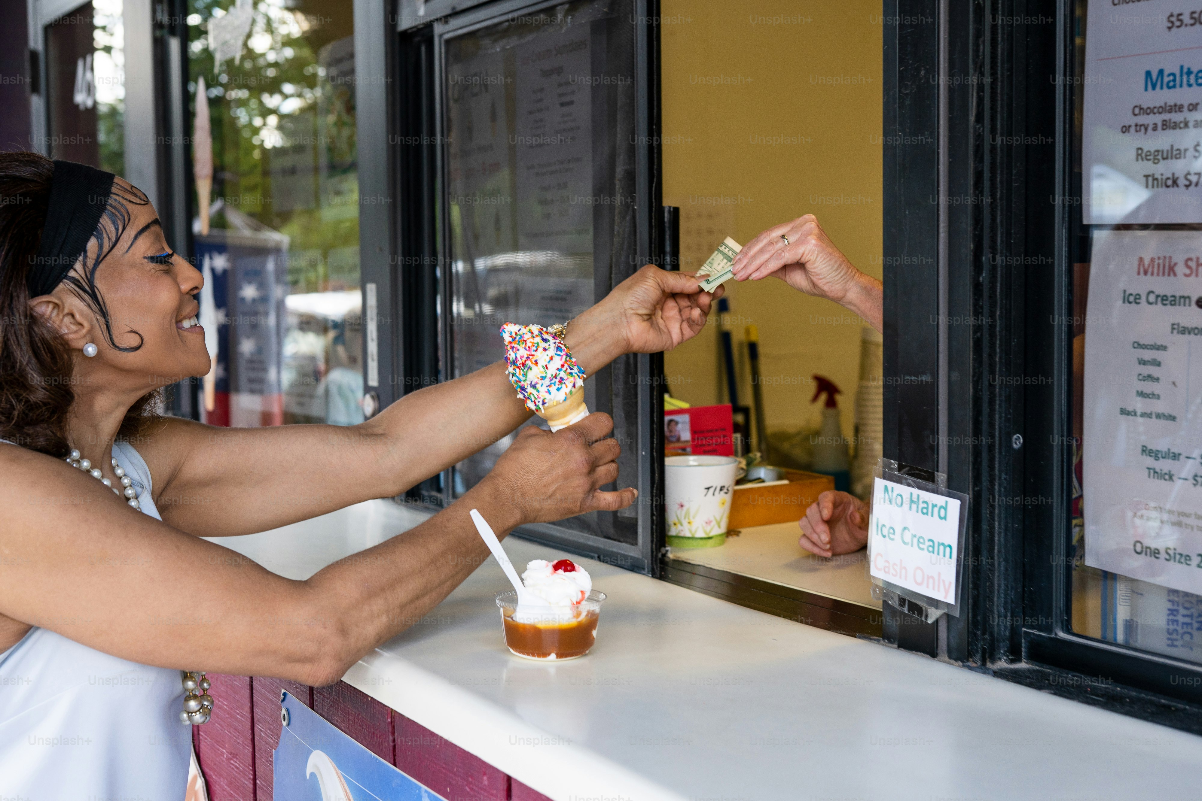 a woman is handing a cupcake to another woman