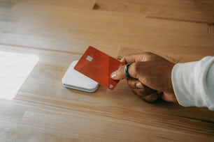 Una persona con una tarjeta de crédito roja y blanca