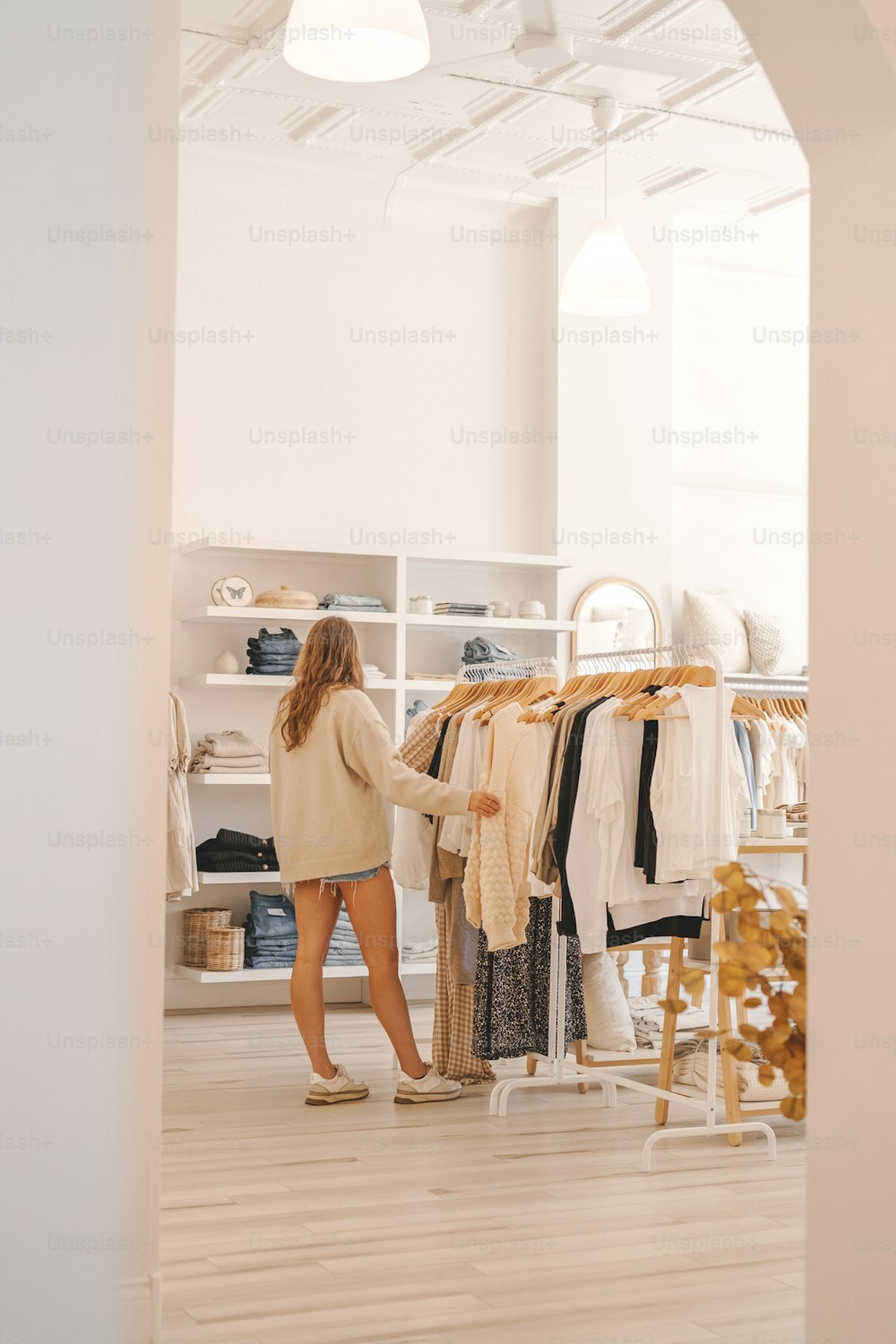 una mujer de pie frente a un perchero de ropa