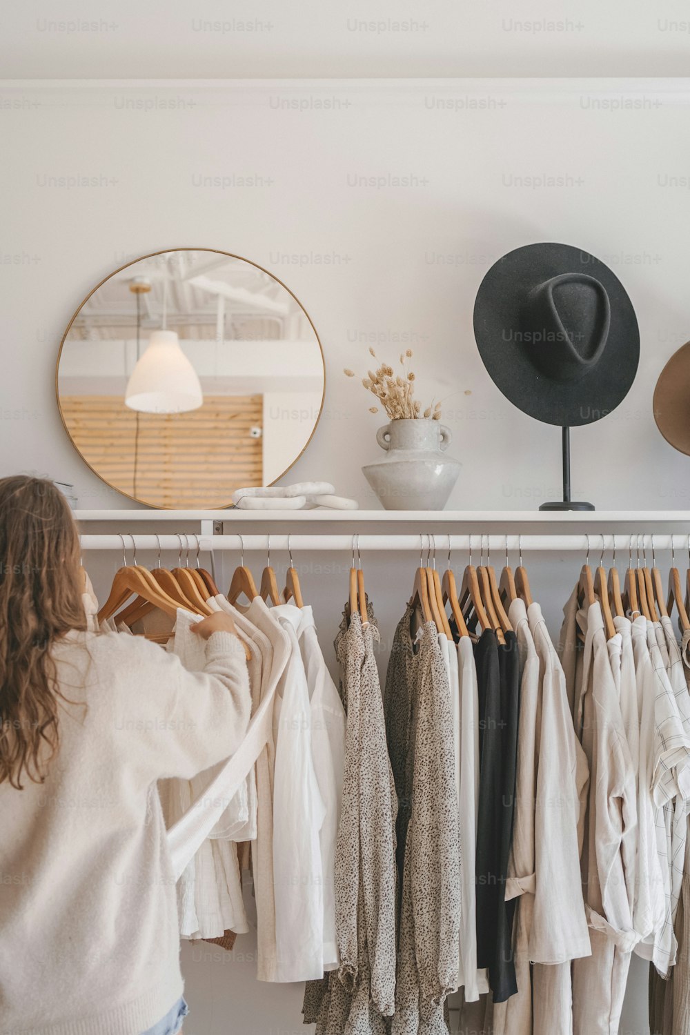 a woman standing in front of a rack of clothes