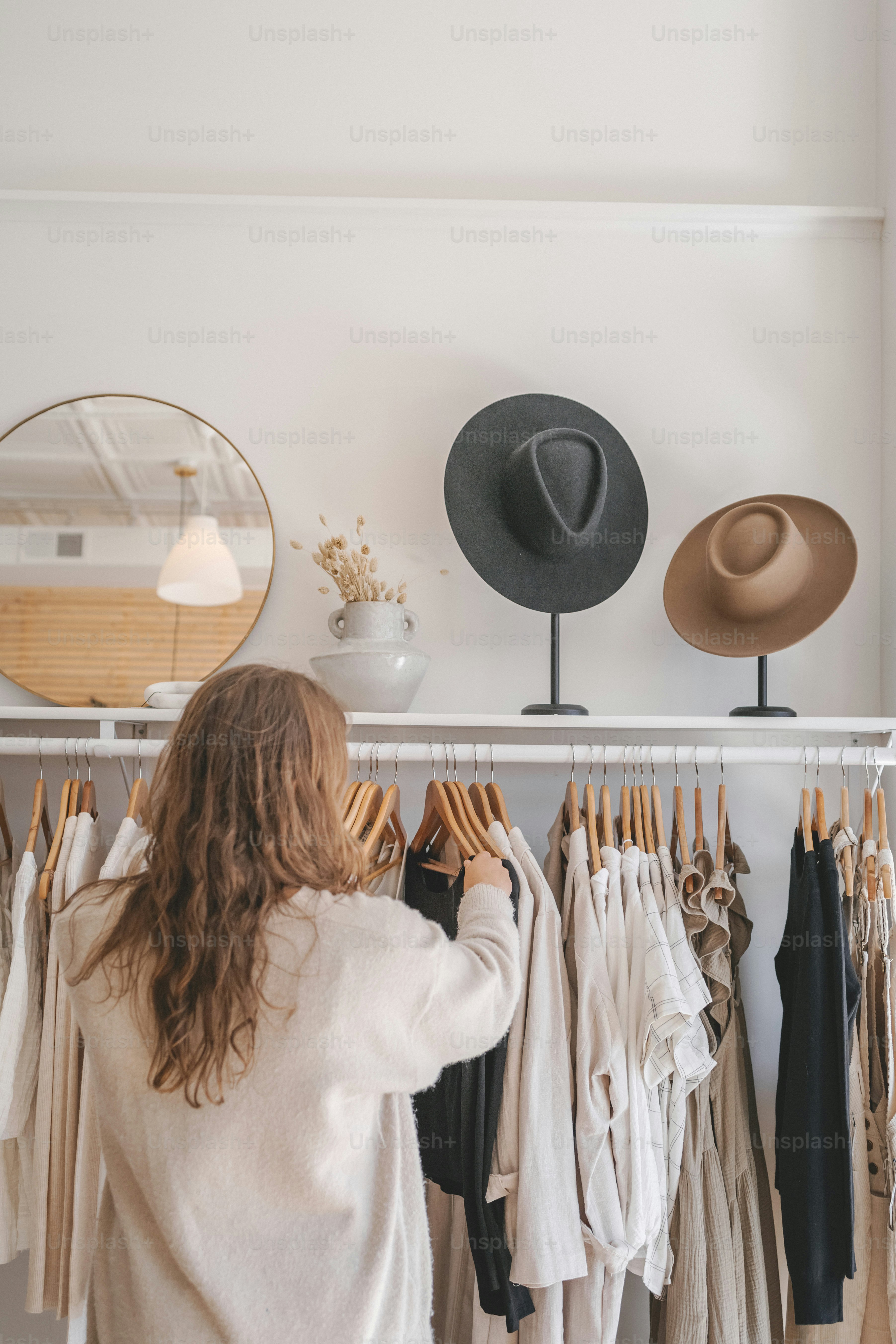 a woman standing in front of a rack of clothes