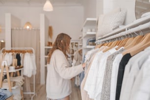 a woman looking at clothes in a clothing store