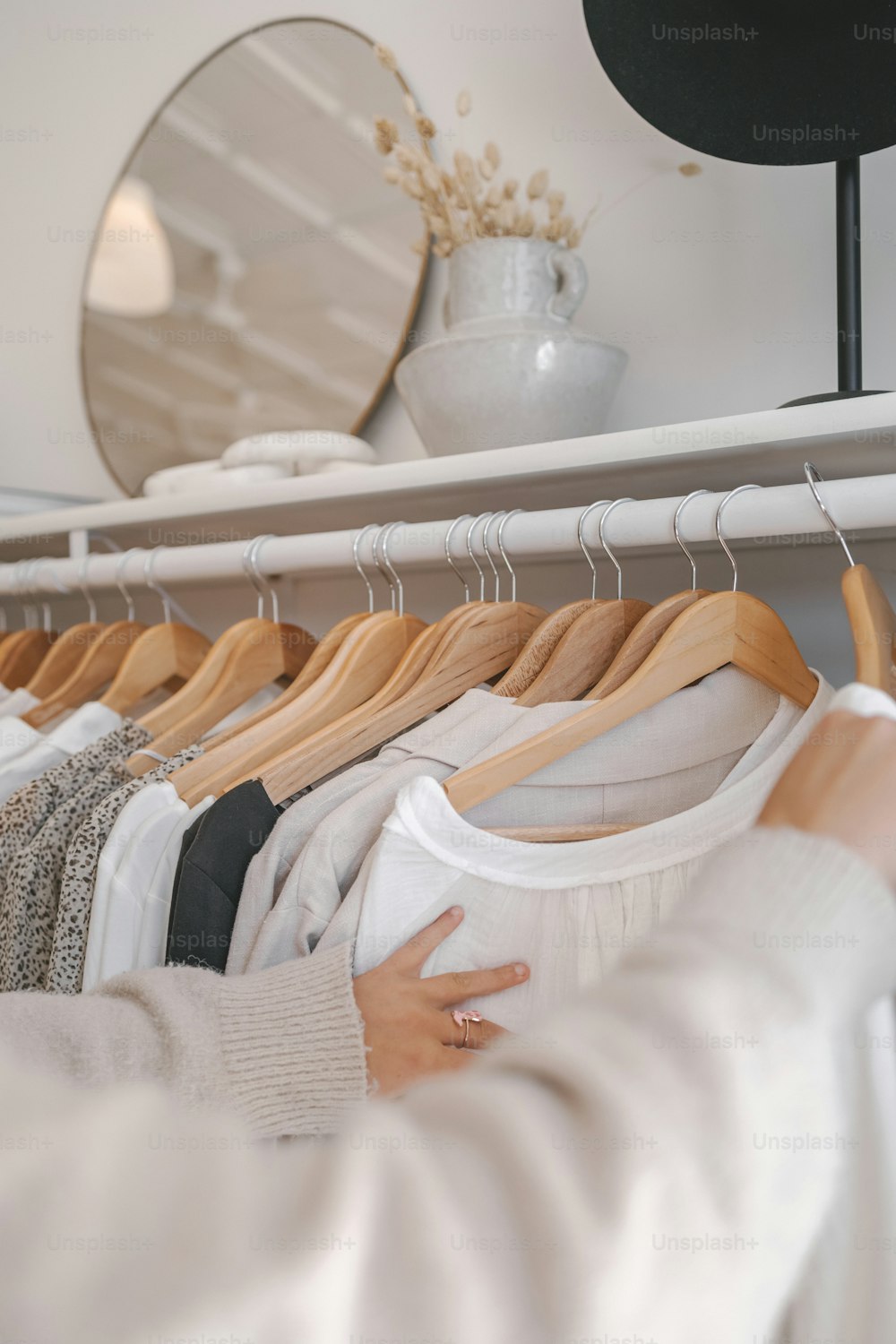 a woman looking at clothes on a rack