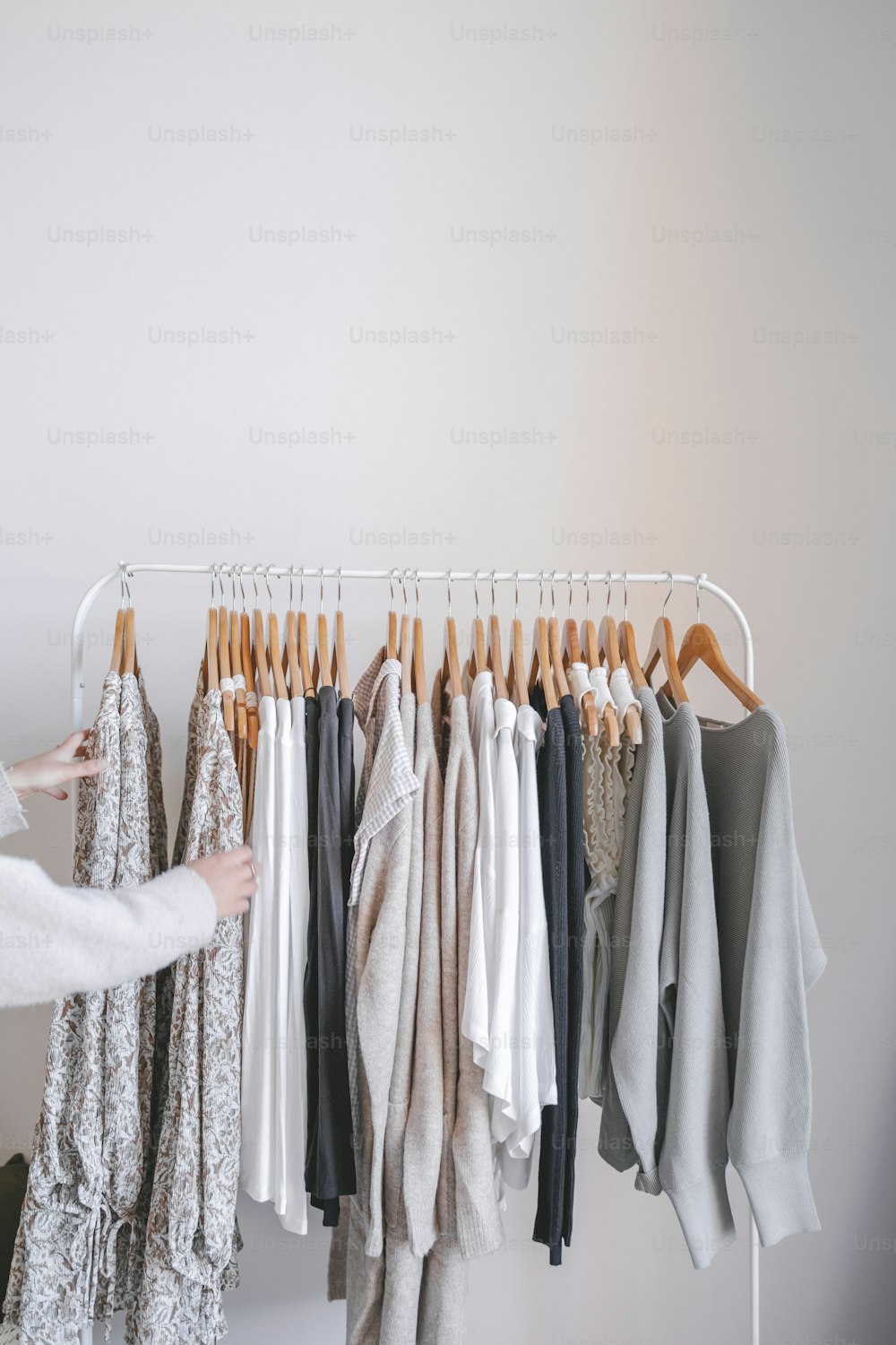 a woman looking at clothes hanging on a rack