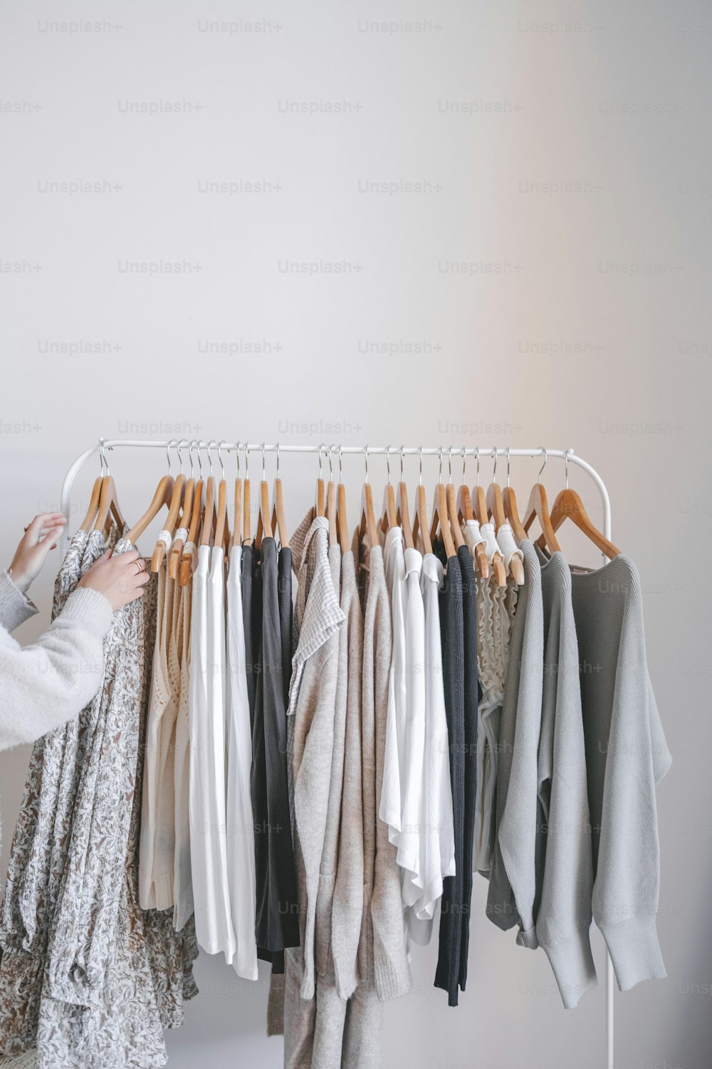 Una mujer parada junto a un estante de ropa