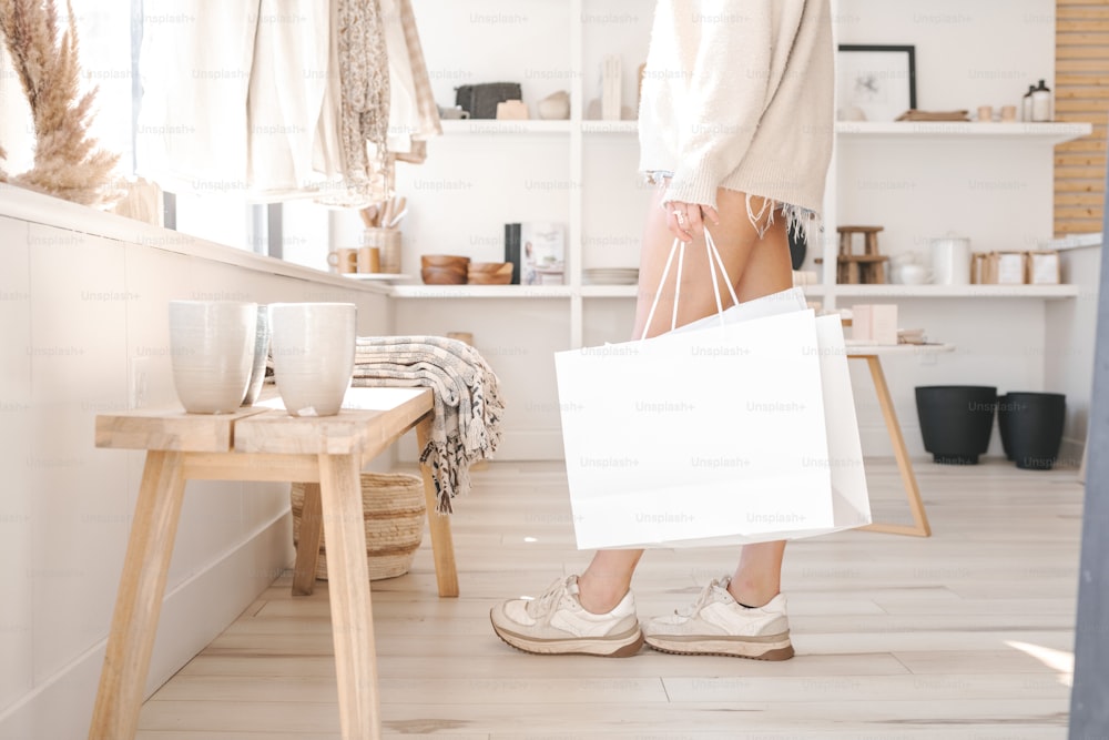 a woman holding a white shopping bag in a store