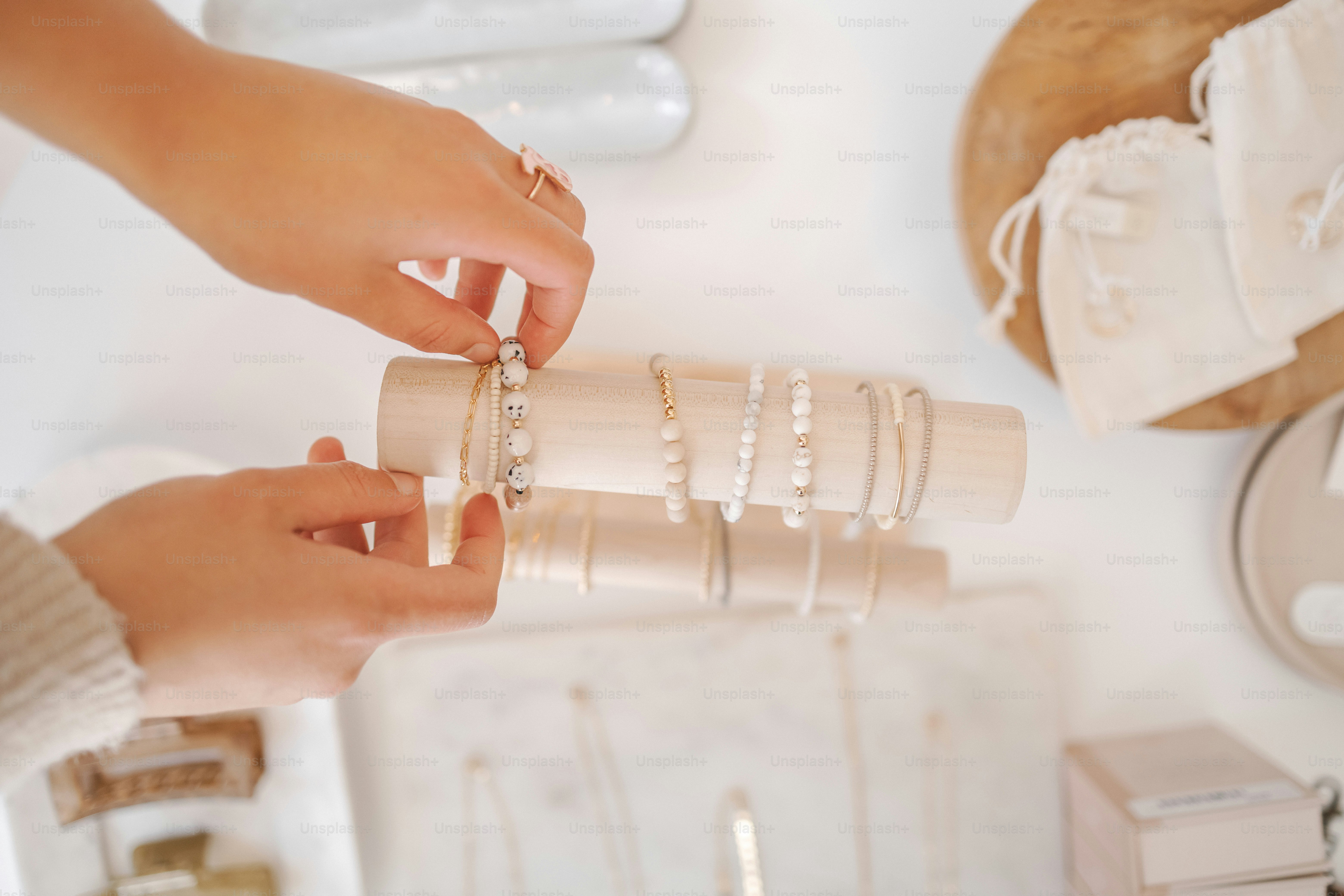 a woman is holding a stack of bracelets