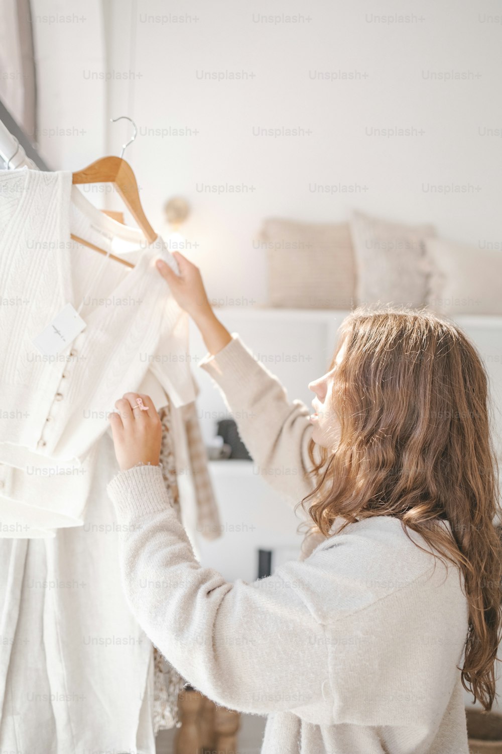 a woman looking at a dress on a hanger