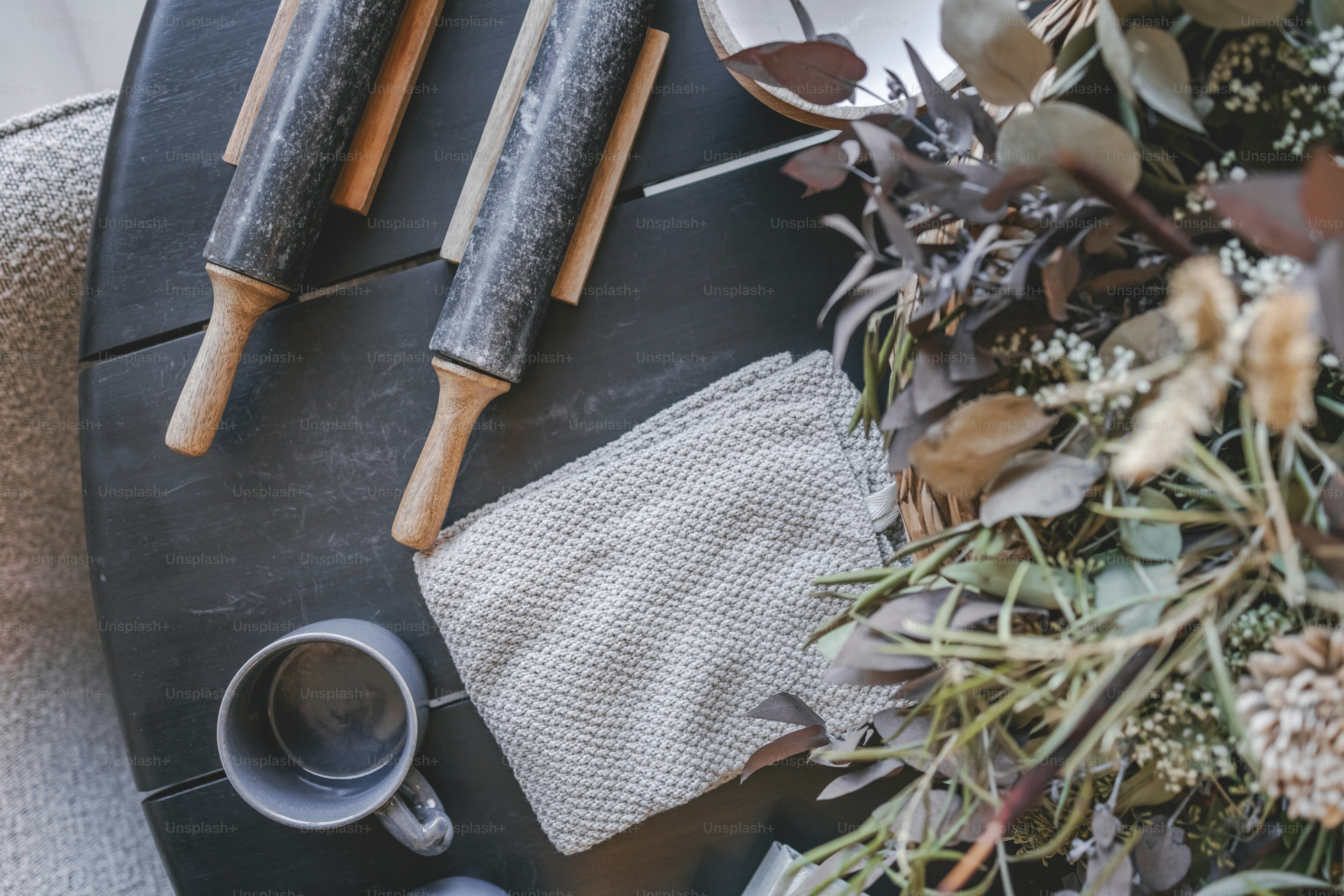 a table topped with a cup of coffee next to two wooden utensils