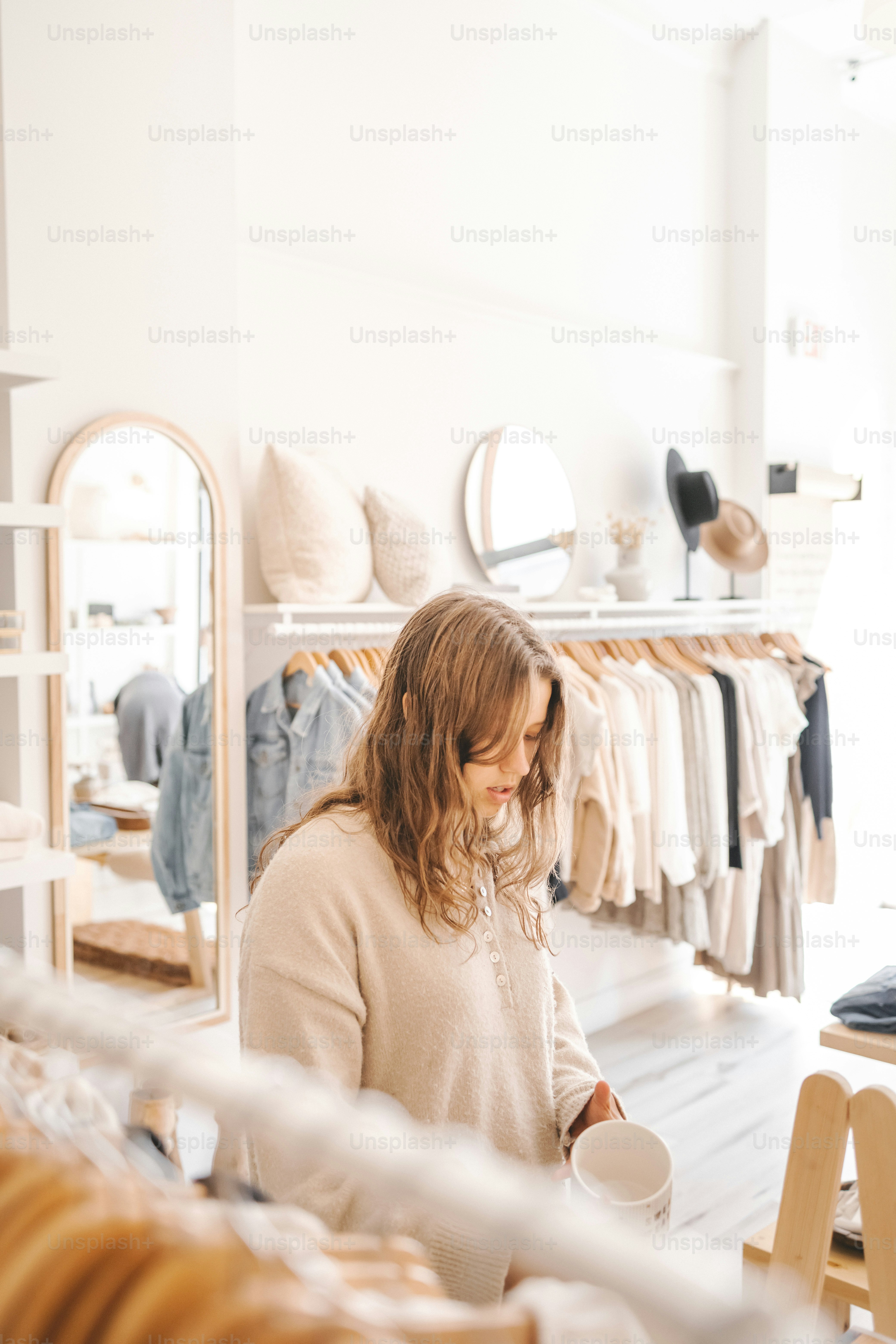 a woman standing in front of a mirror holding a cup