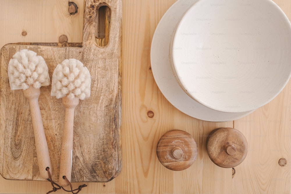 a wooden cutting board topped with two white brushes