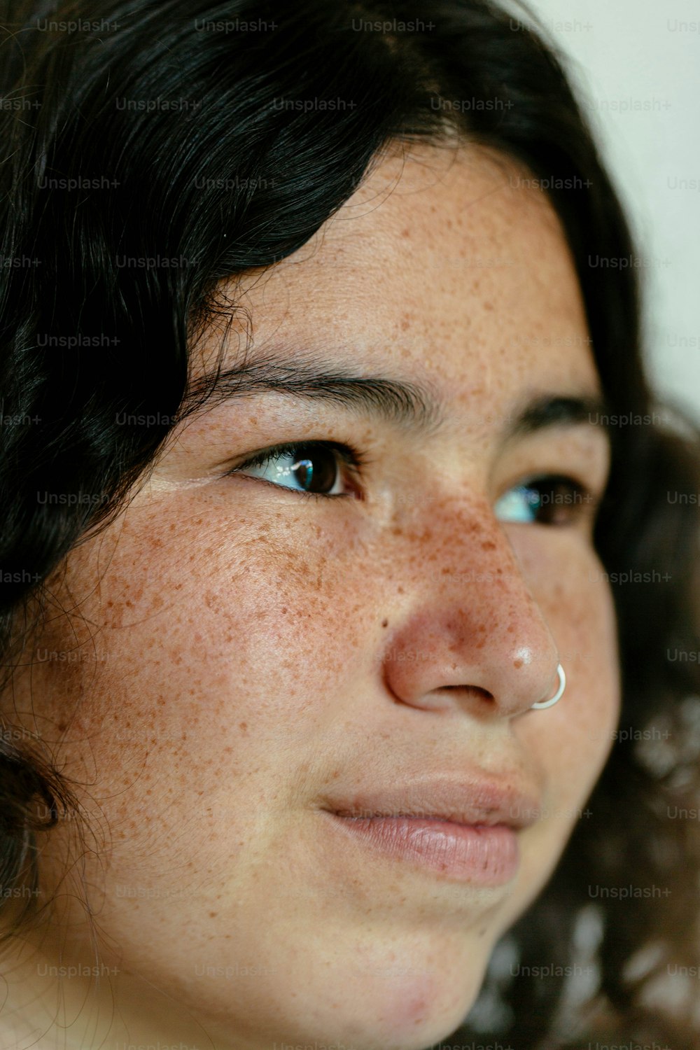 Eine Nahaufnahme einer Frau mit Sommersprossen auf der Nase