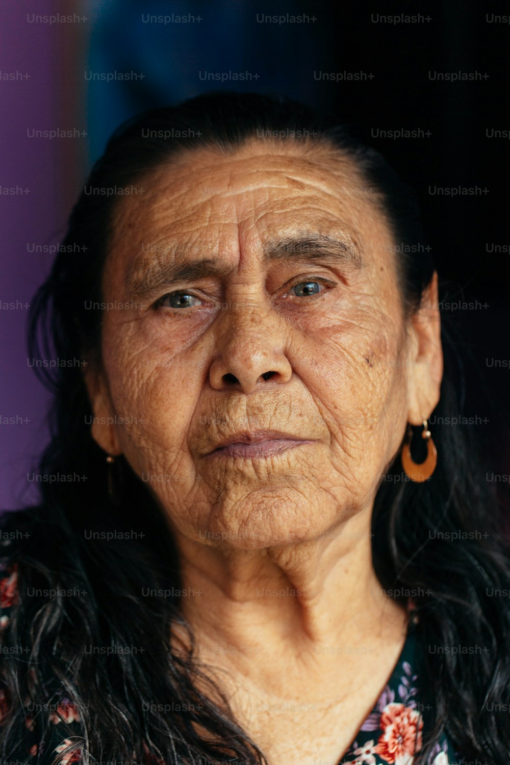 eine alte Frau mit langen Haaren und Ohrringen