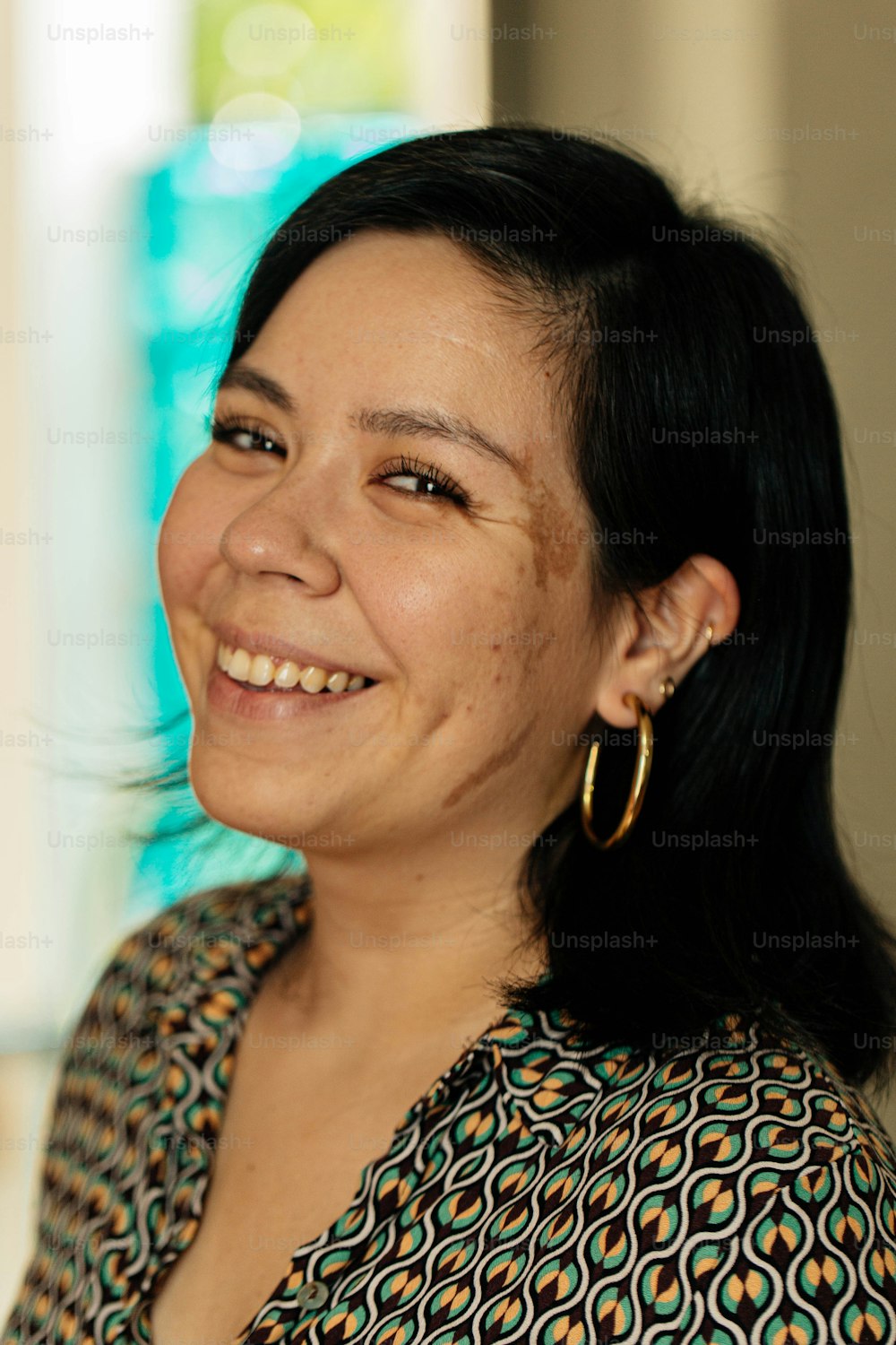a woman with black hair smiling at the camera