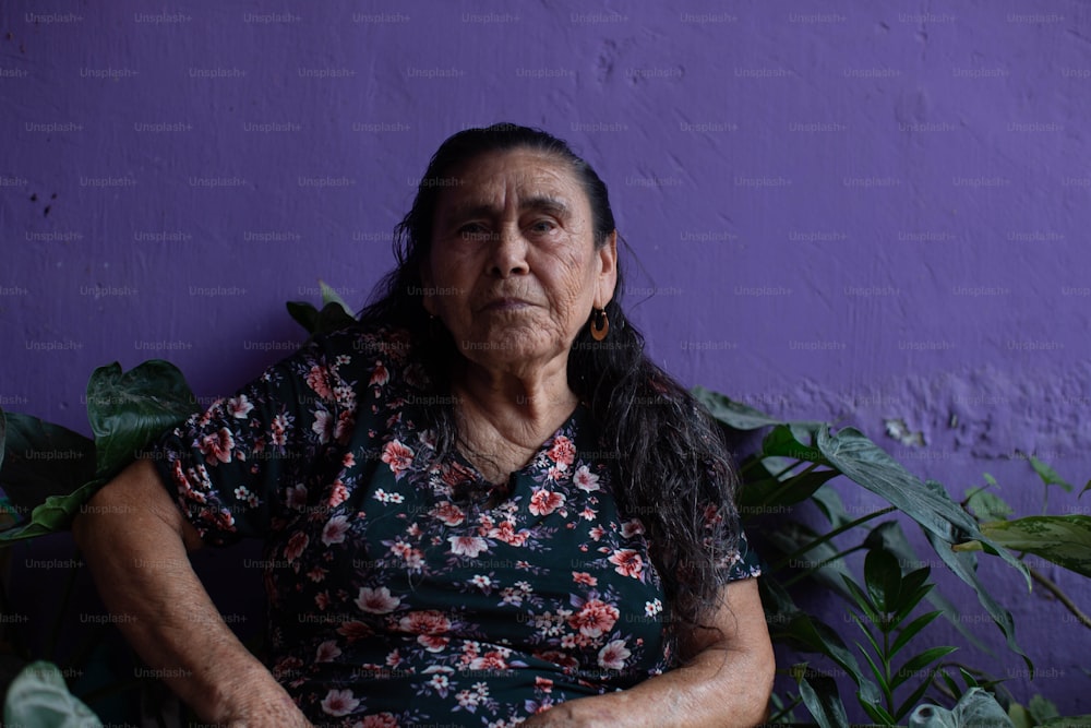 紫色の壁の前に座っている女性