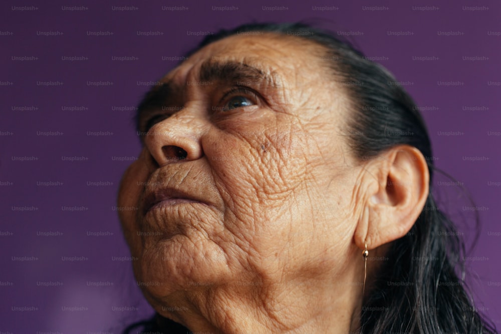 an old woman with long hair looking up