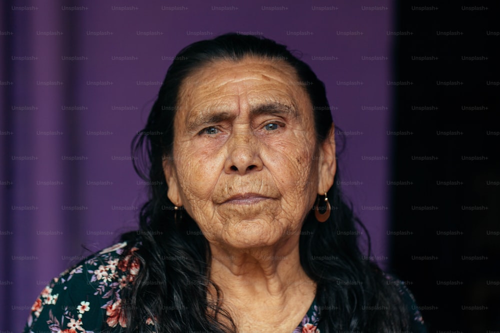 eine alte Frau mit langen Haaren und Ohrringen