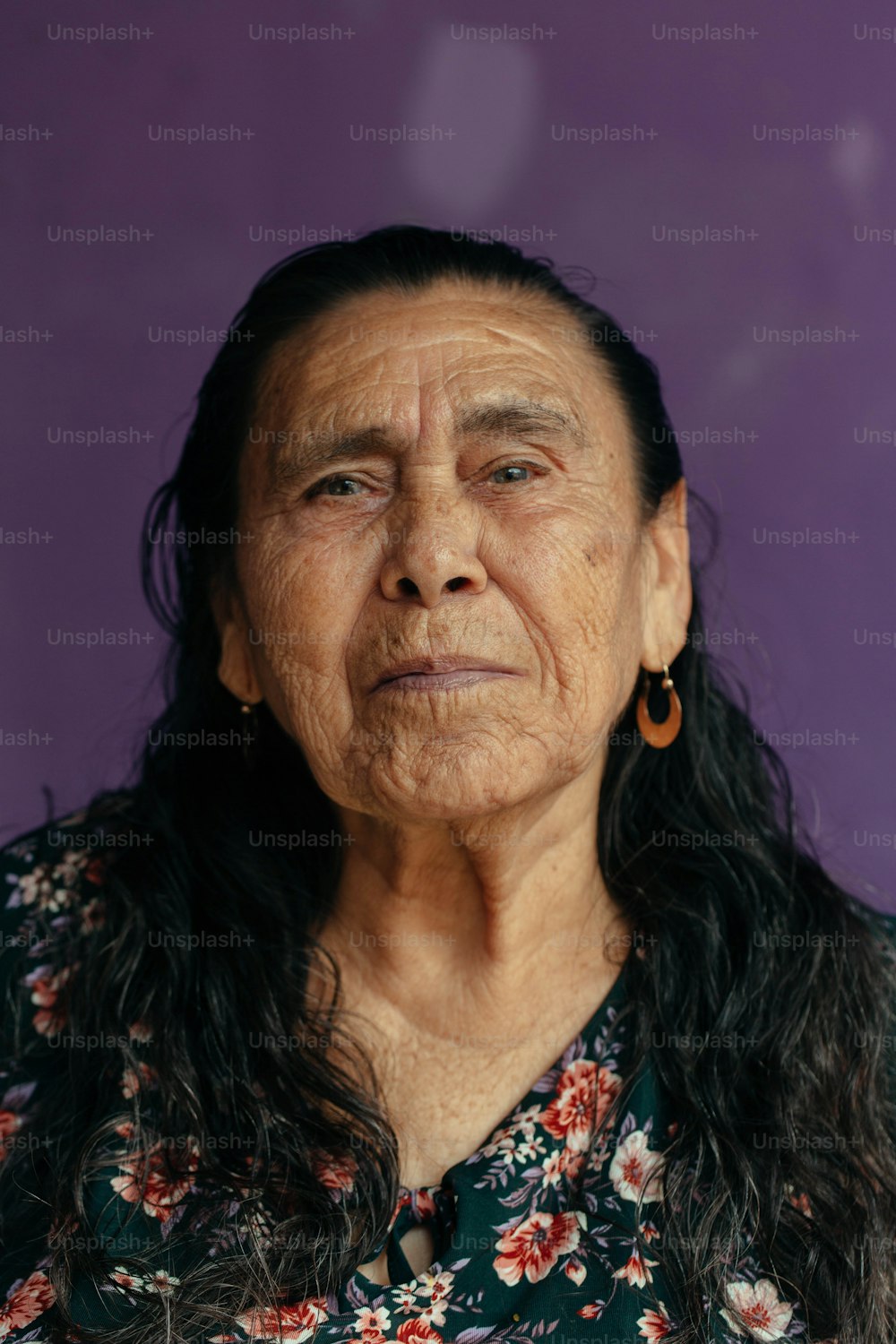 Una donna anziana con capelli lunghi e orecchini