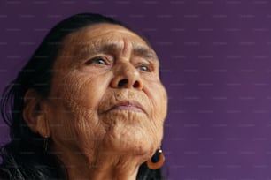 uma mulher velha olhando para cima com um fundo roxo