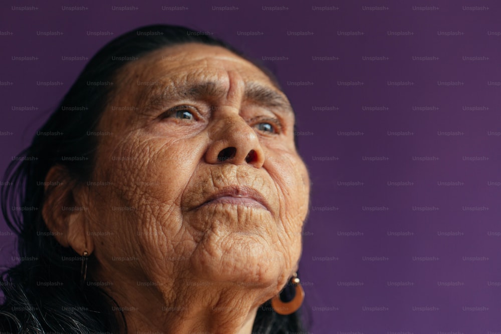 an old woman looking up with a purple background