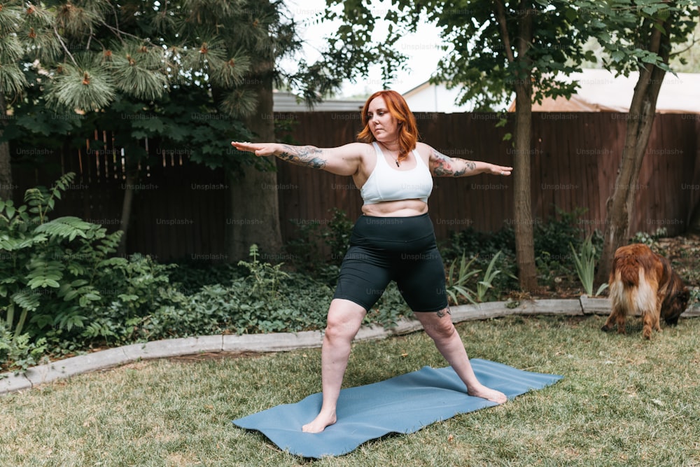 a woman standing on a yoga mat in a yard