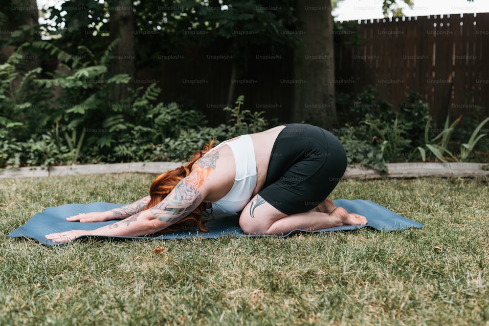 uma mulher em uma pose de ioga em um tapete azul