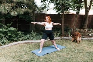 a woman standing on a yoga mat in a yard