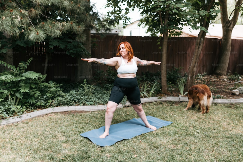 uma mulher em pé em um tapete de ioga em um quintal