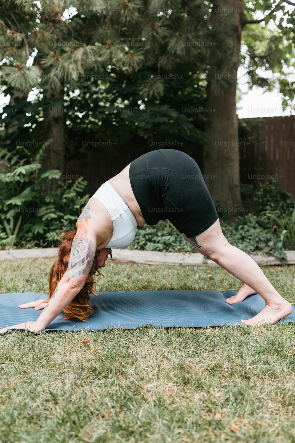 Une femme faisant une pose de yoga sur un tapis bleu