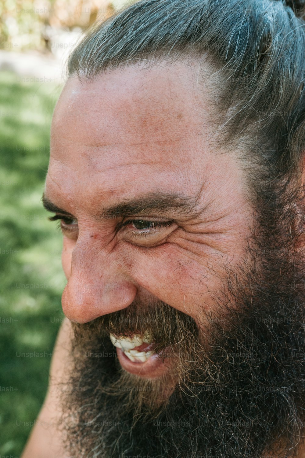 a close up of a man with a beard smiling